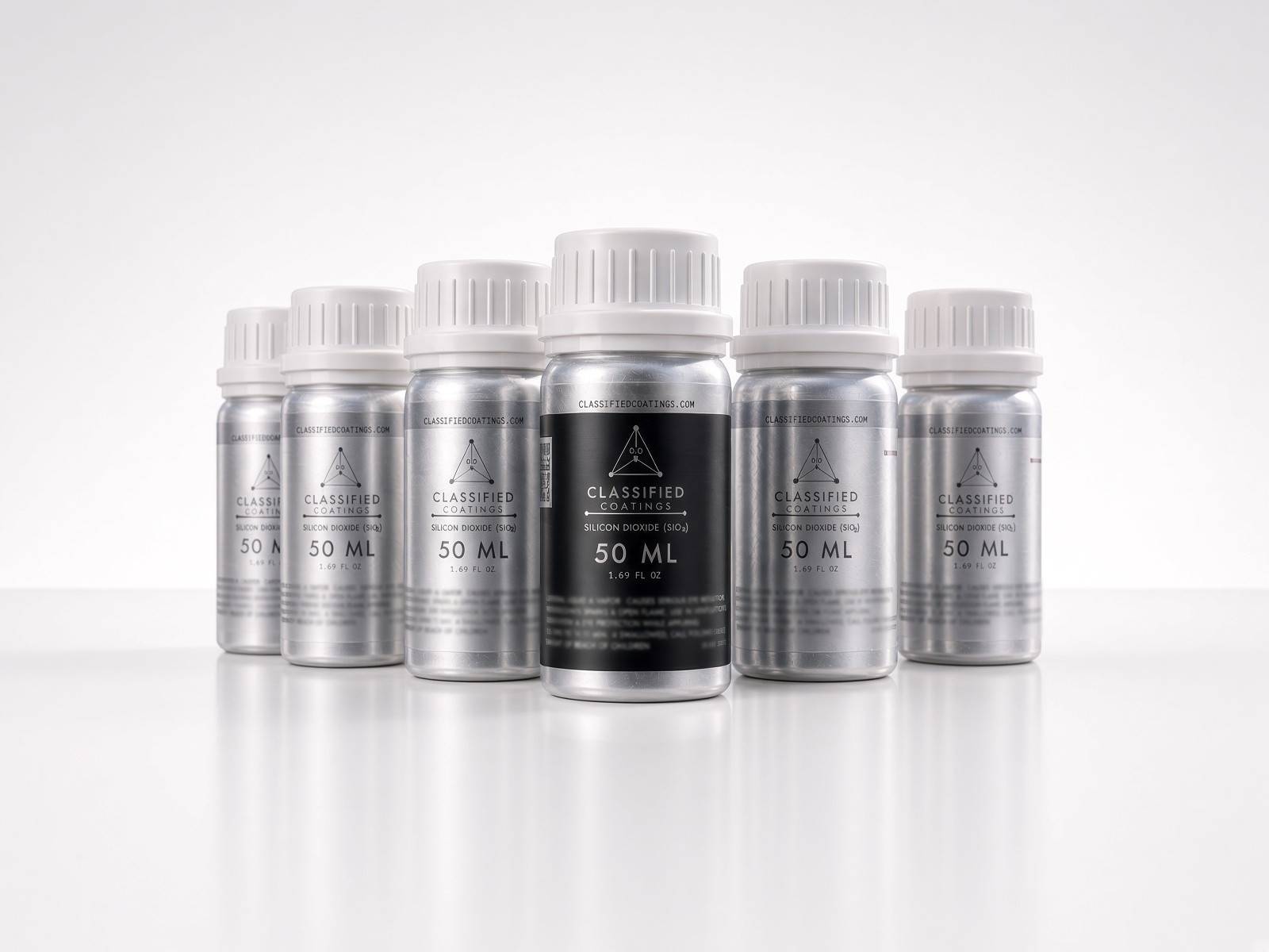 Six 50 ml bottles of Classified Coatings ceramic coating — brushed aluminum with white screw caps, the front bottle wearing a black label — on a white studio floor.